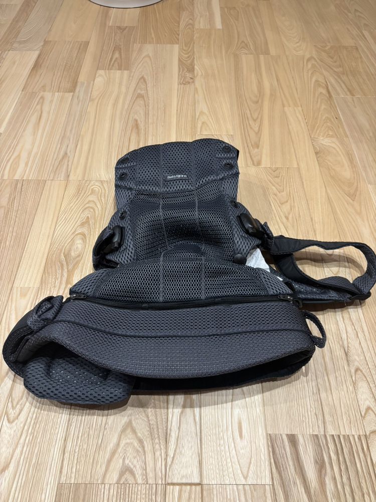 広げたベビーキャリア Harmonyの全体像。ファスナーとストラップ、パッド類が見える