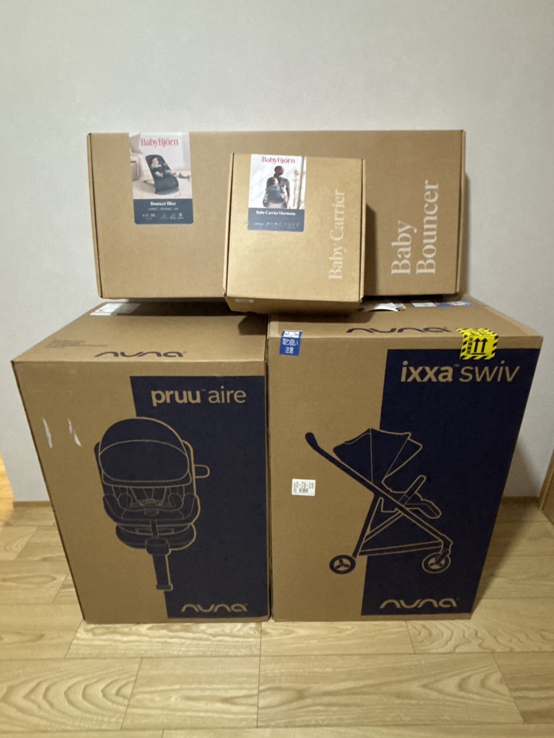 積み重ねた4つの箱。上段にベビービョルンのバウンサーとベビーキャリアの箱、下段にnunaのチャイルドシートとixxa swivの箱