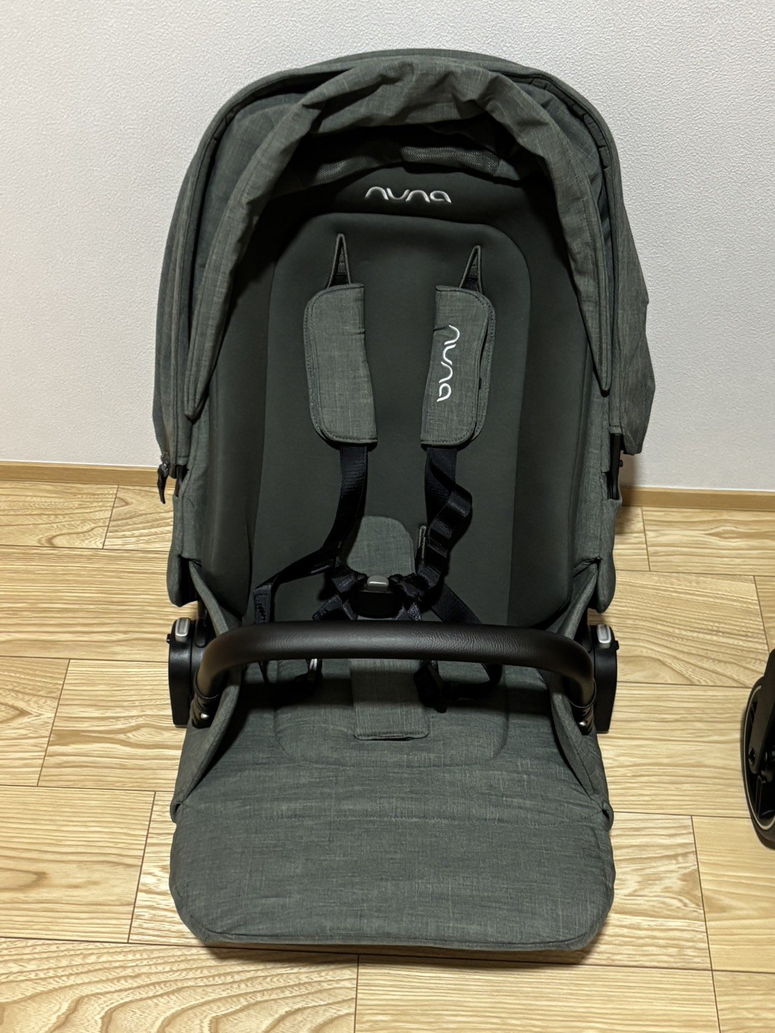 NUNA IXXA swivのシートユニット単体を正面から見たところ。フォレストの生地と幌、ハーネスが見える