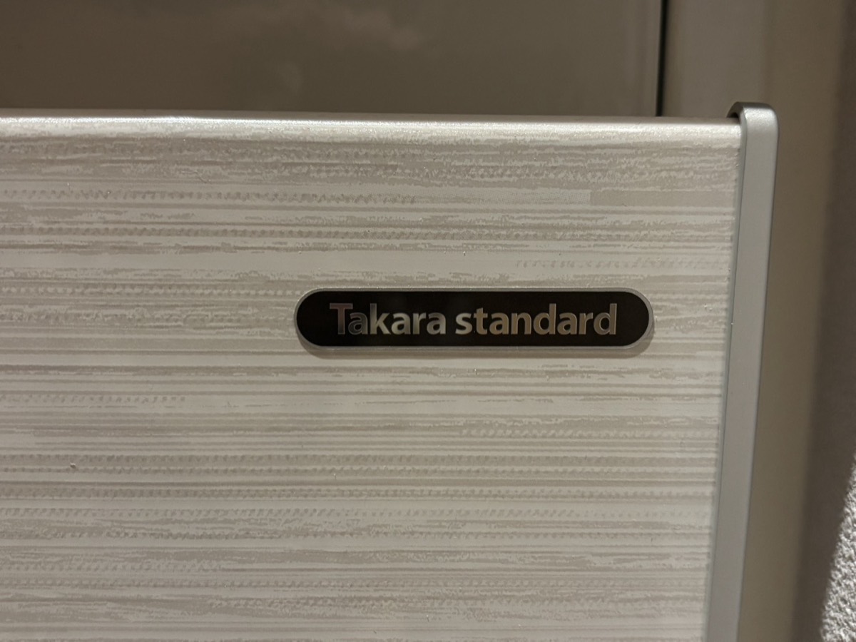 我が家のタカラスタンダード洗面台のキャビネット扉。木目調の柄とTakara standardのエンブレム
